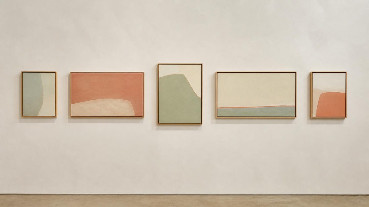 Five framed artworks of varying proportions hung along a single line on a pale gallery wall